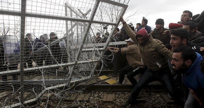 Мигранты пытаются обрушить часть границы во время акции протеста. Архивное фото
