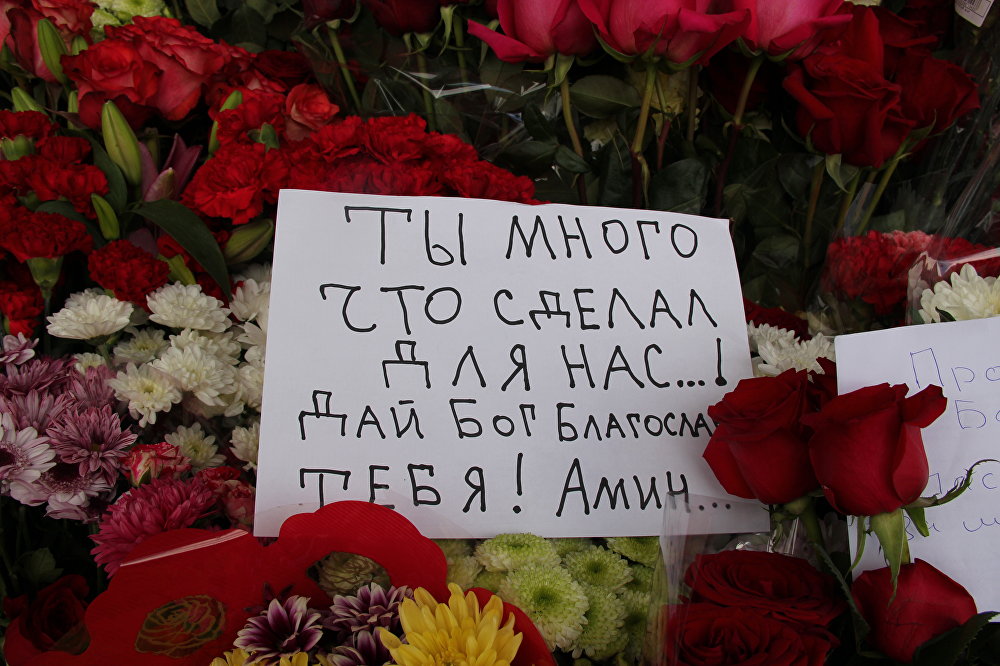 Цветы и записка с соболезнованиями у здания посольства Узбекистана в Москве