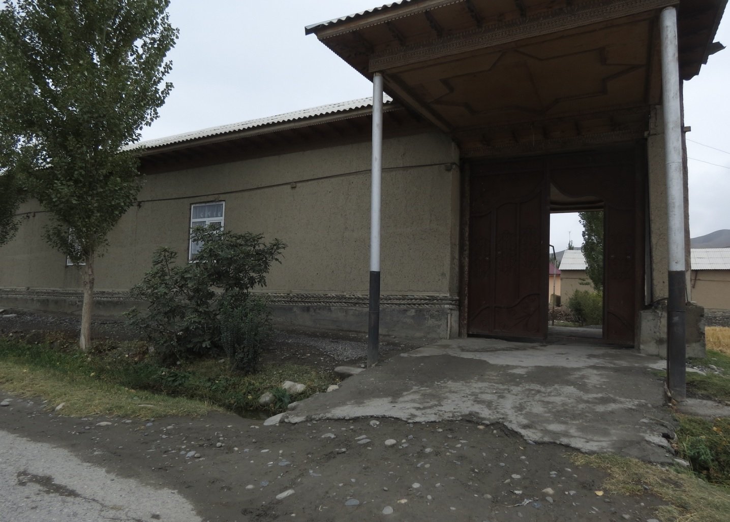 Вдоль улицы стоят типично узбекские дома: огромные усадьбы с глухими фасадами и мощными дарвазами.